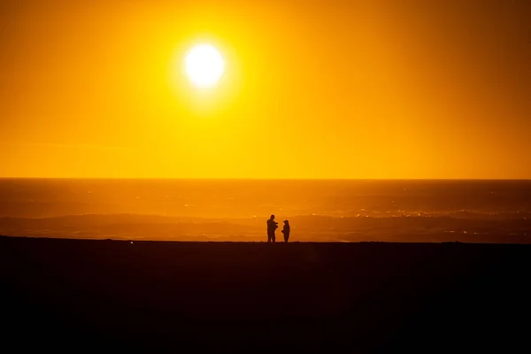 Een Silhouet Van Mensen Met Stralende Zon Boven Zee — Stockfoto