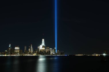 Gece körfezden gelen parlak neon ışıklarıyla New York gökdeleninin büyüleyici manzarası.