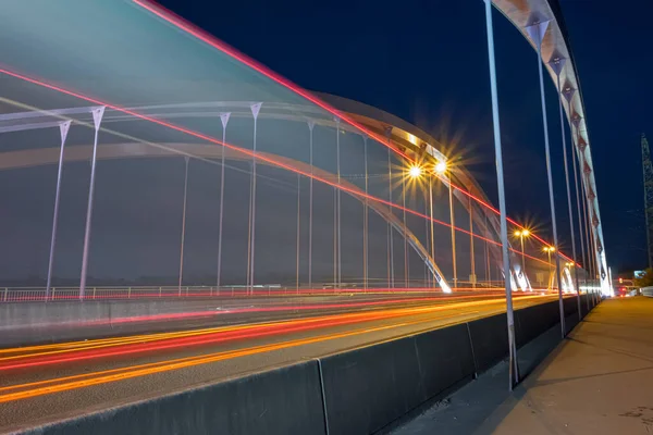 夜間の車のライトに長い露出効果を持つ橋の美しいショット — ストック写真