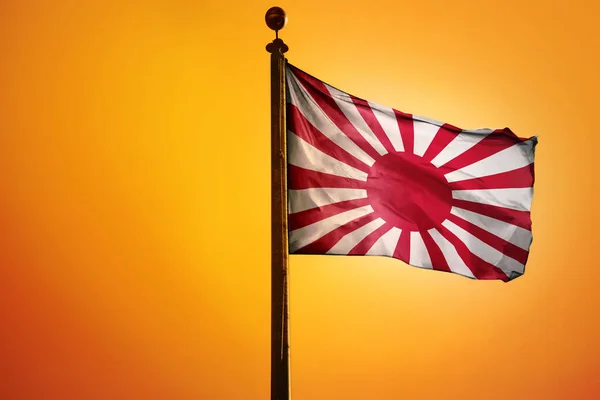 在橙色背景下孤立的旗杆上的日本古老国旗 — 图库照片