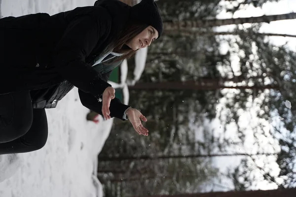 冬の森で遊んでいる若い女性の垂直ショット — ストック写真
