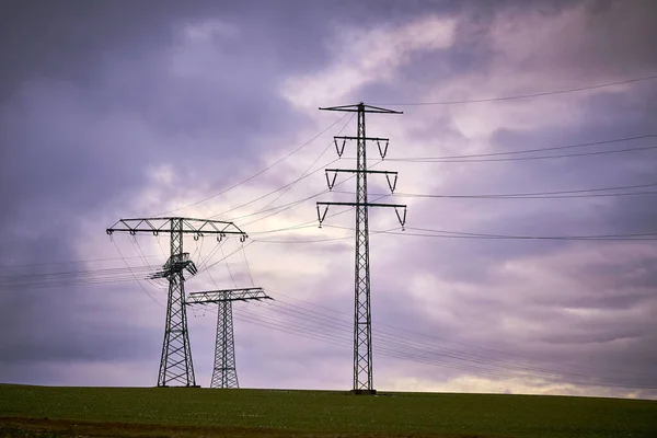 紫色の空に対する電気パイロンの眺め — ストック写真