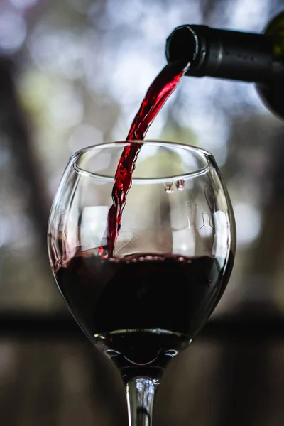 Κόκκινο Κρασί Χύνεται Από Ένα Μπουκάλι Ένα Ποτήρι Κρασί Ένα — Φωτογραφία Αρχείου