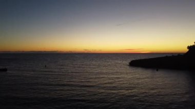 İspanya 'nın Mallorca sahilinde deniz suyu ve ufuk çizgisi üzerinde kayalık bir uçurum manzarası.