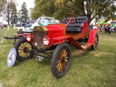 Eski kırmızı Ford Model T Roadster 'ı Tudor 1920 dolaylarında. Yan görüş. Doğa yeşili çimenler ve ağaçlar. Klasik araba şovu. Kopyalama alanı
