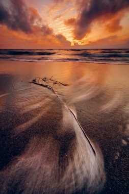 Baltık Denizi kıyısında gün batımının büyüleyici bir görüntüsü.