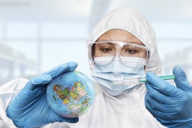 Bir doktor laboratuardaki Dünya gezegenine Coronavirus aşısı enjekte ediyor.