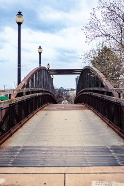 Tren raylarındaki paslı, eski demir bir köprünün dikey görüntüsü.