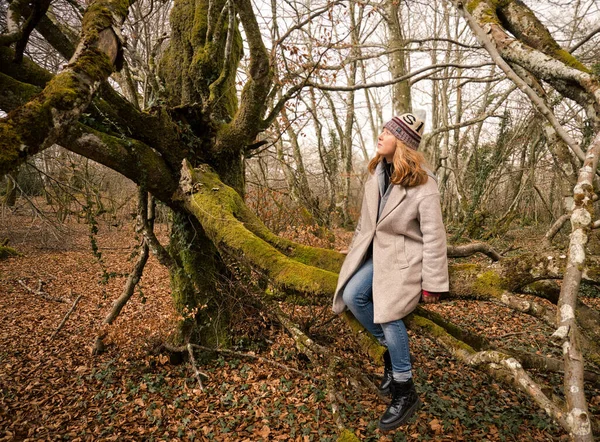Beyaz Bir Kadın Ormanda Yosunlu Bir Ağaç Gövdesinde Oturuyor — Stok fotoğraf