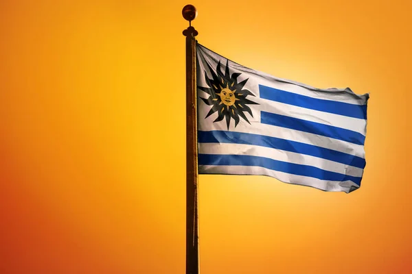 在橙色背景上的一根杆子上挂着一面飘扬的乌拉圭国旗的3D渲染 — 图库照片
