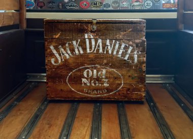 Eski ahşap Jack Daniels Old No. Bir kamyonetin yatağında 7 kutu viski. Amblem logosu ve marka. Beyaz harfler.