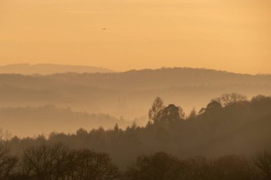 Gün batımında bulutlu gökyüzünün altında güzel bir manzara.