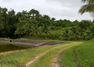 Gölet boyunca yolda yürüyen gezginler
