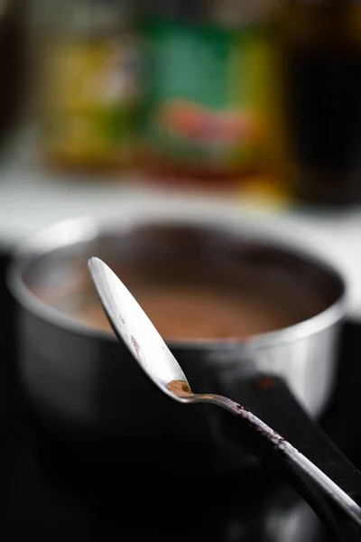 Egy Függőleges Felvétel Egy Spatuláról Csokoládé Krém Hátterében Egy Edényben — Stock Fotó