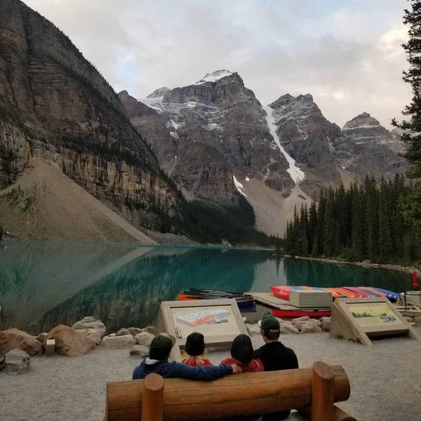 View People Sitting Wooden Bench Moraine Lake Surrounded Snow Covered — Stock Photo, Image