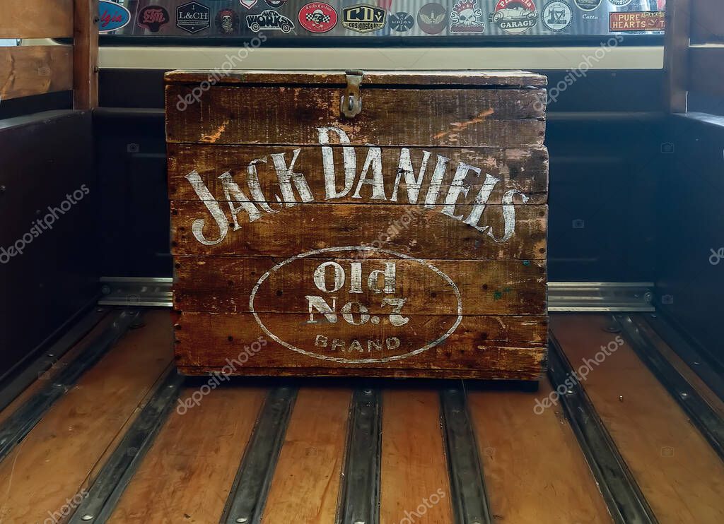 Worn wooden Jack Daniels Old No. 7 whiskey box on the bed of a pickup truck. Emblem logo and brand. White letters.