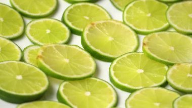 Üzerinde su damlaları olan yeşil limon dilimlerinin dönüşümlü görüntüsü.