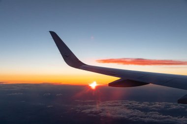 Gün batımında bir uçağın kanadının penceresinden güzel bir çekim.