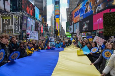 Katılımcılar Times Square, New York 'ta Ukrayna' ya destek vermek için Ukrayna bayrakları taşıyorlar