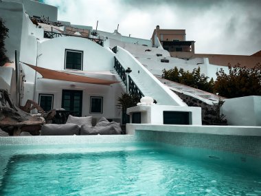 Mykonos 'ta yüzme havuzunun arkasındaki beyaz bina manzarası