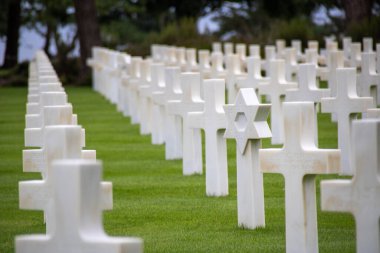 Bulutlu gökyüzünün altındaki Normandiya Amerikan Mezarlığı ve Anıtı