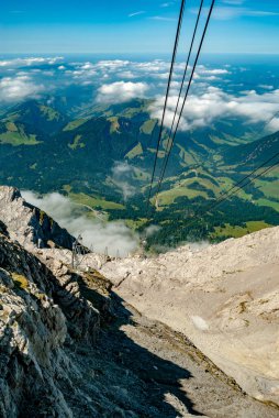 Teleferikten güzel bulutlu dağların dikey görüntüsü.