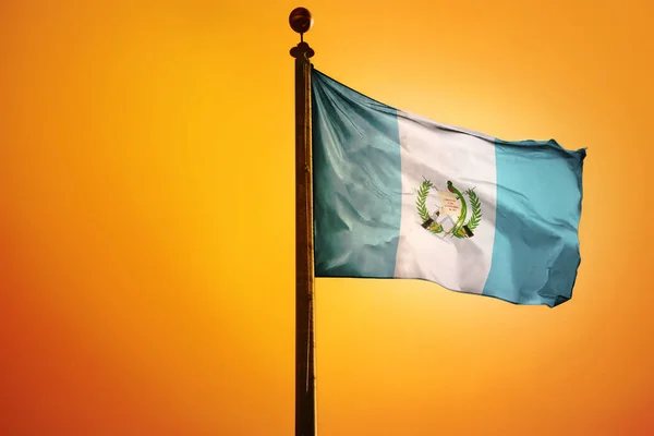 在橙色背景下孤立的旗杆上的危地马拉国旗 — 图库照片