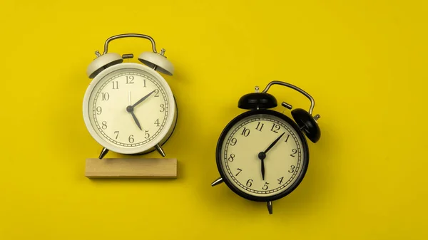時計のコンセプトのコピースペース 時間の重要性についての時間概念 黄色の背景に黒と白の目覚まし時計の選択的な焦点 — ストック写真