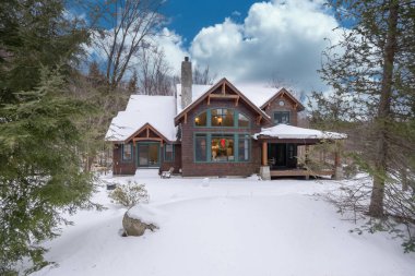 Kış boyunca karla kaplı tuğla bir banliyö evi.