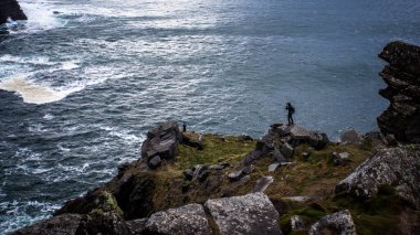Güneşin doğuşunda okyanusa yakın yeşil bir uçurum manzarası.