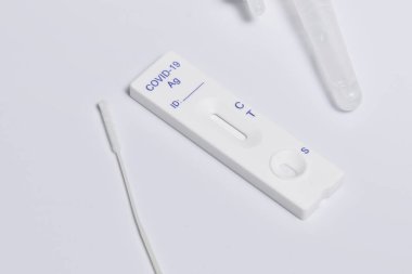 Beyaz arkaplanda izole edilmiş ekspres covid-19 test kasetinin yakın çekimi