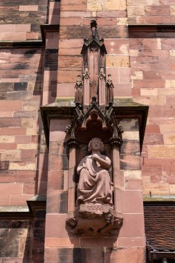 Almanya 'da güneşli bir günde Freiburg Munster Katedrali' nin ön cephesindeki heykellerin dikey görüntüsü.
