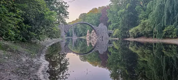 穏やかな水の中の橋や木の反射 — ストック写真