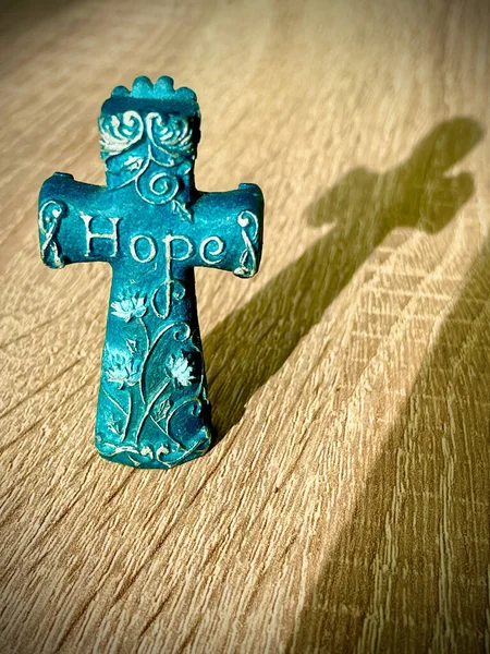 Small Blue Crucifix Word Hope Flower Pattern Reflecting Wooden Surface — Stock Photo, Image