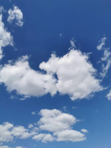 果てしなく続く青い空に綿のような白い雲の垂直ショット — ストック写真
