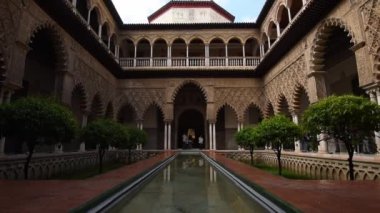 Alcazar, Sevilla, İspanya 'nın sarayındaki havuzun ve bahçenin büyüleyici manzarası.