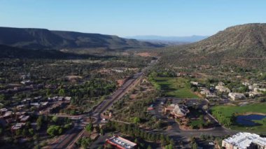 Asfalt yolları ve mavi gökyüzü arka planında dağları olan güzel bir manzaranın hava görüntüleri.