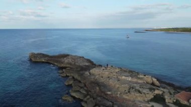 İspanya 'nın Mallorca sahilinde deniz suyu ve ufuktaki kayalık bir uçurumun hava manzarası.