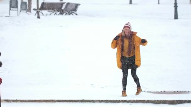 Uma Mulher Feliz Nova Uma Jaqueta Amarela Salta Sob Neve — Vídeo de Stock