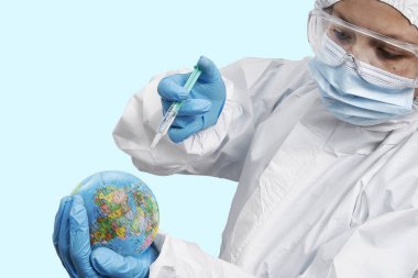 Bir doktor laboratuardaki Dünya gezegenine Coronavirus aşısı enjekte ediyor.