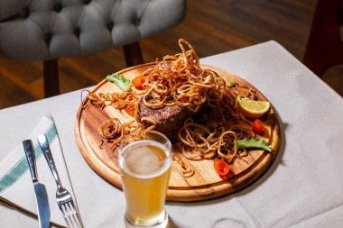 Karamelli soğan ve domatesle servis edilen lezzetli ızgara et. ve limon