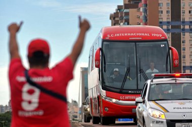 Porto Alegre, Rio Grande do Sul, Brazil - 1st Mar, 2015: A Sport Club Internacional fan waving to the team's bus on its way to a match clipart