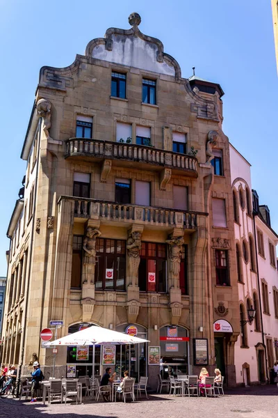 ドイツのフライブルクの美しい歴史的建造物の下でファーストフードレストランの垂直ショット — ストック写真