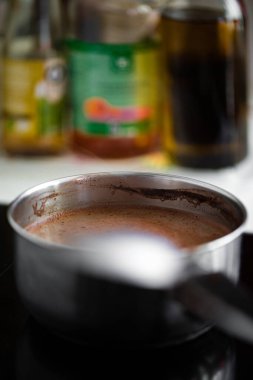 Gaz ocağındaki tencerede duran çikolatalı kremanın dikey görüntüsü.