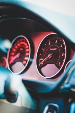 Bir arabanın içindeki kırmızı ve siyah hız göstergelerine yakın çekim