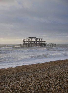 Brighton sahili ve günbatımında eski bir rıhtımın dikey çekimi, İngiltere.