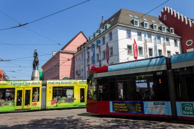Freiburg, Almanya ve Avrupa şehir merkezinden iki renkli tramvay geçiyor.