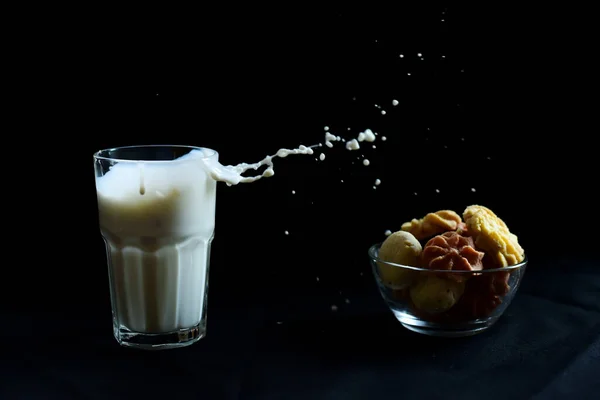 Una Veduta Bicchiere Con Latte Schizzato Fuori Una Ciotola Biscotti — Foto Stock