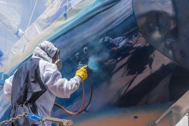 Tam vücut koruması ve yelkenlinin gövdesini boyayan bir sprey boyacı.