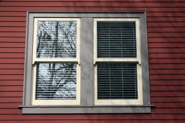 Kahverengi tuğladan bir duvarda güzel ve küçük gri bir pencere tasarımı.